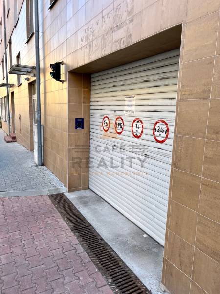 Na predaj parkovacie miesto, Beskydská, Bratislava, Staré Mesto - Brána garáže na budove s bezpečnostnými značeniami; blízko betónového chodníka.