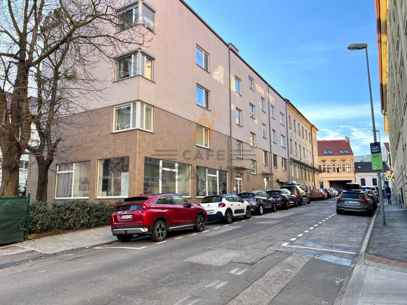 Na predaj parkovacie miesto, Beskydská, Bratislava, Staré Mesto - Ulica s autami, budovami, stromami, v pozadí modrá obloha a zaparkované garáže.