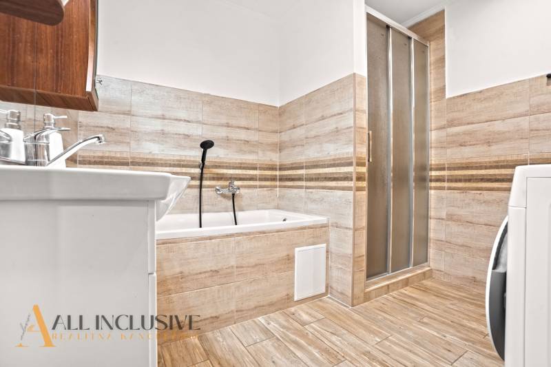 NA PREDAJ 4-IZBOVÝ RODINNÝ DOM V KOLÁROVE - Kúpeľňa s vaňou a sprchovacím kútom v rodinnom dome, podlaha s dreveným dekorom.