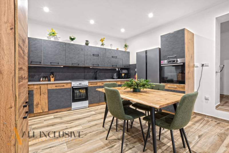 NA PREDAJ 4-IZBOVÝ RODINNÝ DOM V KOLÁROVE - Kuchyňa v rodinnom dome s podlahou s dreveným dekorom a moderným nábytkom.