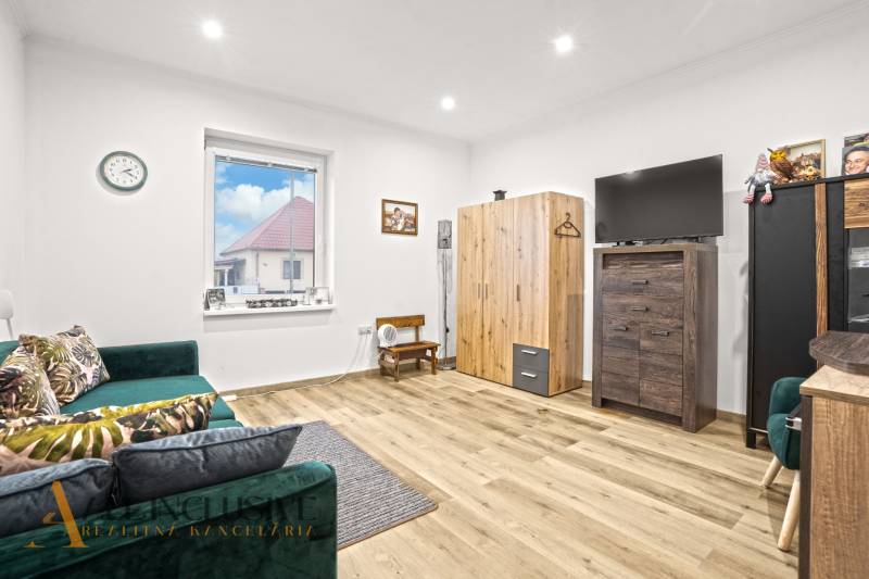 NA PREDAJ 4-IZBOVÝ RODINNÝ DOM V KOLÁROVE - Obývačka v rodinnom dome s pohovkou, televízorom a podlahou s dreveným dekorom.