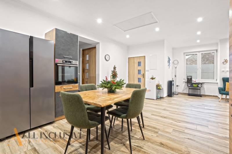 NA PREDAJ 4-IZBOVÝ RODINNÝ DOM V KOLÁROVE - Kuchyňa s jedálenským stolom a podlahou s dreveným dekorom v rodinnom dome.