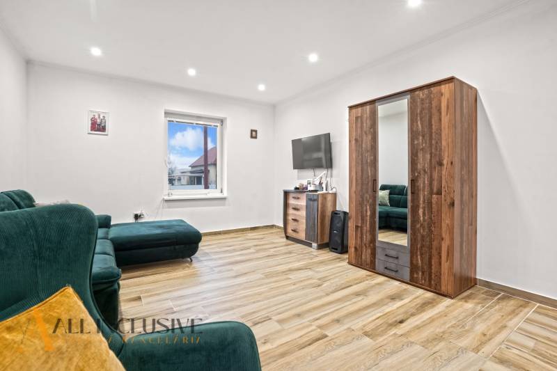 NA PREDAJ 4-IZBOVÝ RODINNÝ DOM V KOLÁROVE - Obývacia izba v rodinnom dome s pohovkou, skrinkou a podlahou s dreveným dekorom.