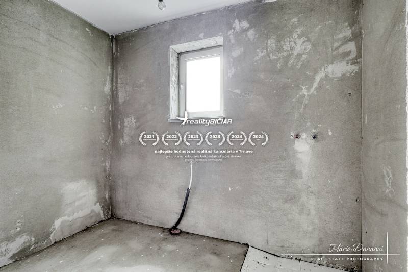 Novostavba 4-izbového rodinného domu v obci Slov.Nová Ves - Betónová stena a malé okno v interiéri rodinného domu.