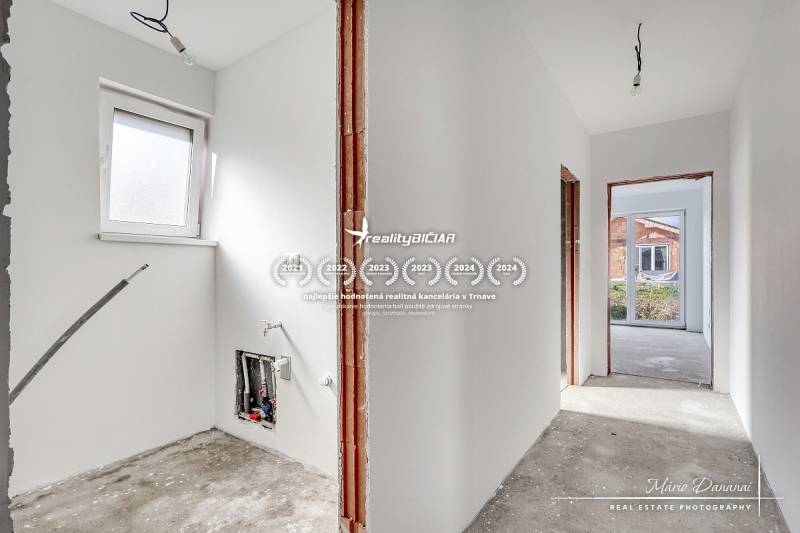 Novostavba 4-izbového rodinného domu v obci Slov.Nová Ves - Interiér rodinného domu s nedokončenou podlahou a bielymi stenami.