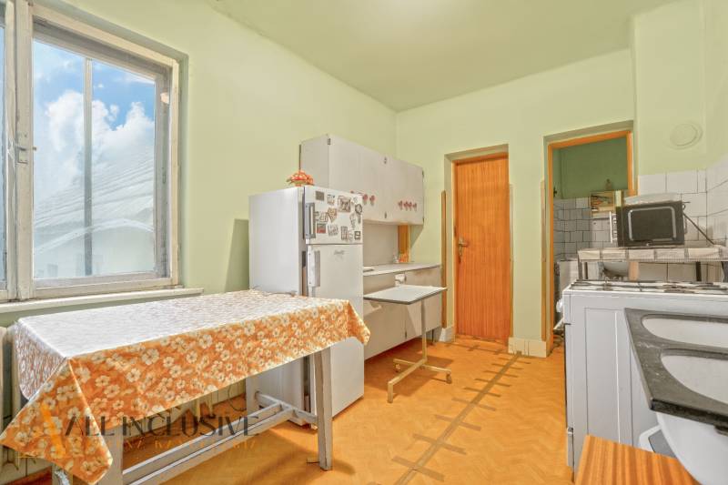 NA PREDAJ 3-IZBOVÝ RODINNÝ DOM VO VEĽKOM BLAHOVE - Kuchyňa v rodinnom dome s podlahou s dreveným dekorom, kuchynskou linkou a stolom.