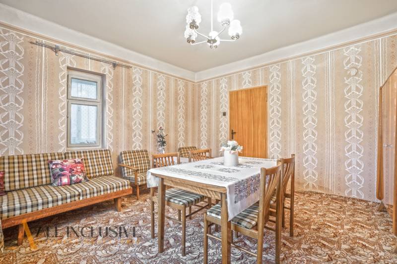 NA PREDAJ 3-IZBOVÝ RODINNÝ DOM VO VEĽKOM BLAHOVE - Jedáleň v rodinnom dome so vzorovanými tapetami a dreveným nábytkom.