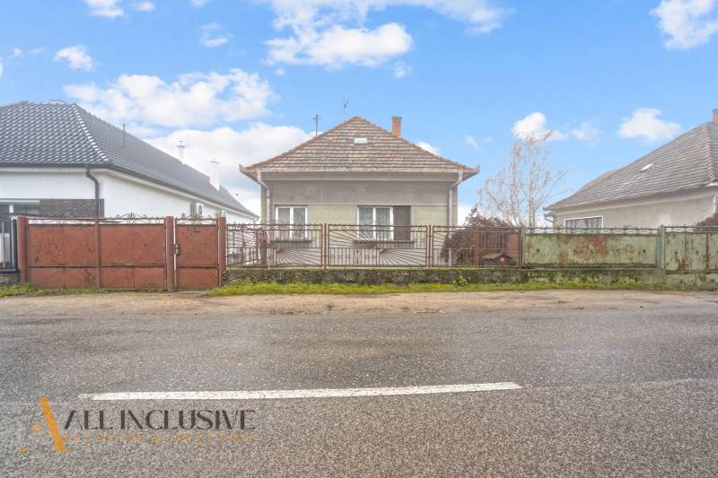 NA PREDAJ 3-IZBOVÝ RODINNÝ DOM VO VEĽKOM BLAHOVE - Rodinný dom v Veľkom Blahove so záhradou a kovovým plotom, iný dom vpravo.