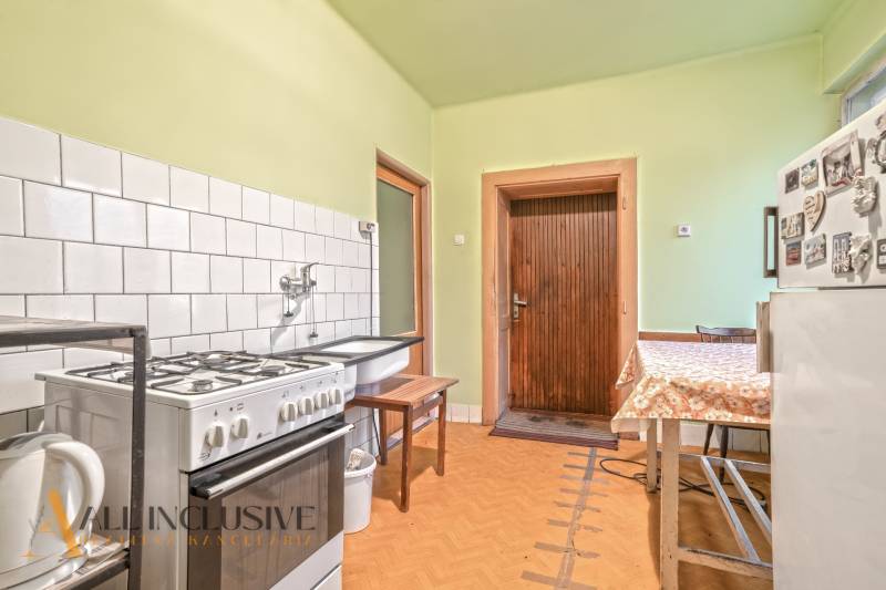 NA PREDAJ 3-IZBOVÝ RODINNÝ DOM VO VEĽKOM BLAHOVE - Kuchyňa v rodinnom dome s podlahou s dreveným dekorom, bielym dlaždicovým obkladom.