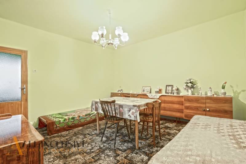 NA PREDAJ 3-IZBOVÝ RODINNÝ DOM VO VEĽKOM BLAHOVE - Jedáleň v rodinnom dome s kobercom, dreveným stolom, stoličkami a skrinkou.