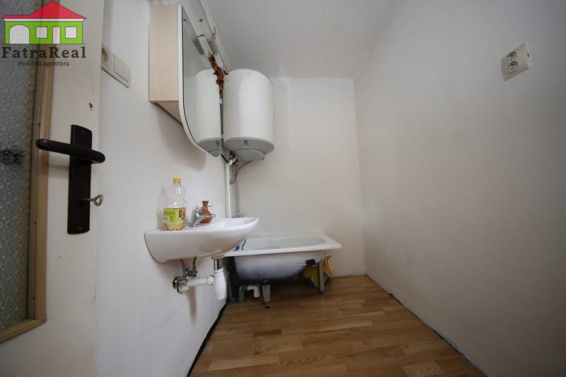 3-izb. byt v rekonštrukcii, Ľubochňa okres Ružomberok - Kúpeľňa v 3-izbovom byte s umývadlom, vaňou, bojlerom a podlahou s dreveným dekorom.