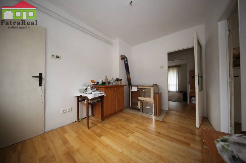 3-izb. byt v rekonštrukcii, Ľubochňa okres Ružomberok - Podlaha s dreveným dekorom, nábytok a biele steny v 3-izbovom byte.