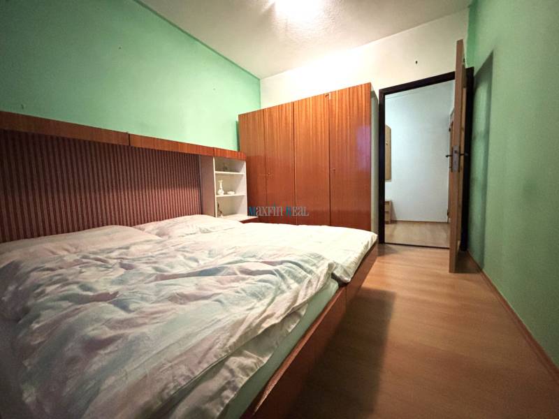 MAXFIN REAL - predaj dvojgarsónky - Nitra, Klokočina - Dvojgarsónka so vstavanými skriňami, zelenými stenami a podlahou s dreveným dekorom.