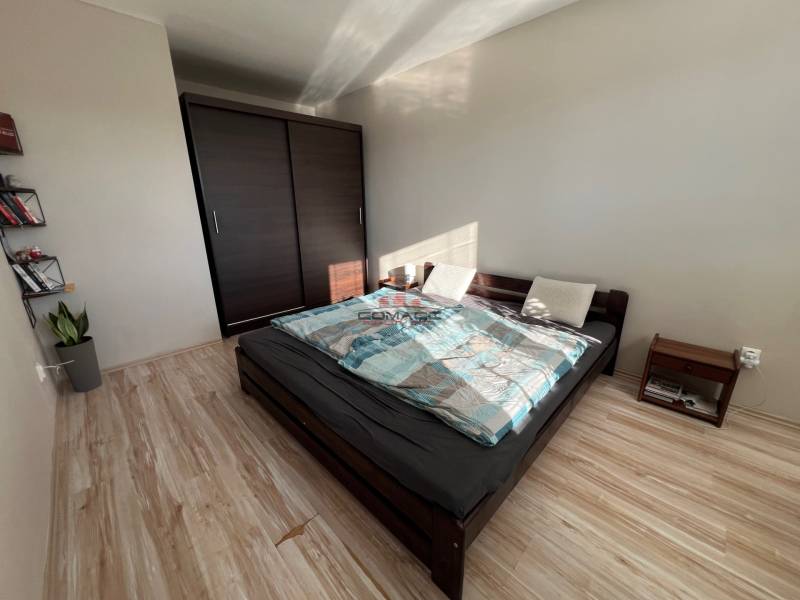 2iz byt v novostavbe Hlohovec Zľava!!! - Spálňa s manželskou posteľou, úložným priestorom a podlahou s dreveným dekorom v 2-izbovom byte.