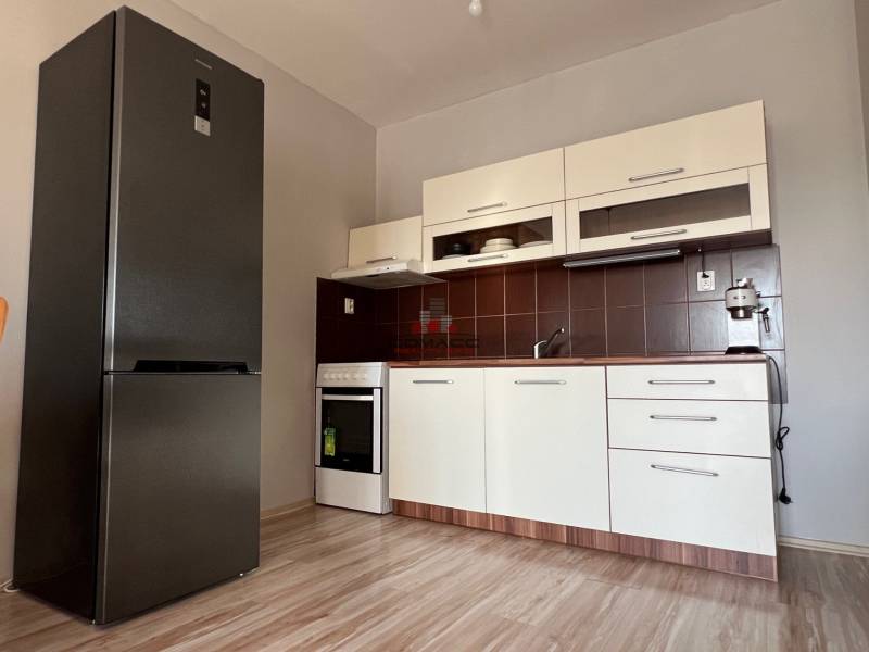 2iz byt v novostavbe Hlohovec Zľava!!! - Kuchyňa v 2-izbovom byte s podlahou s dreveným dekorom, bielou linkou a spotrebičmi.