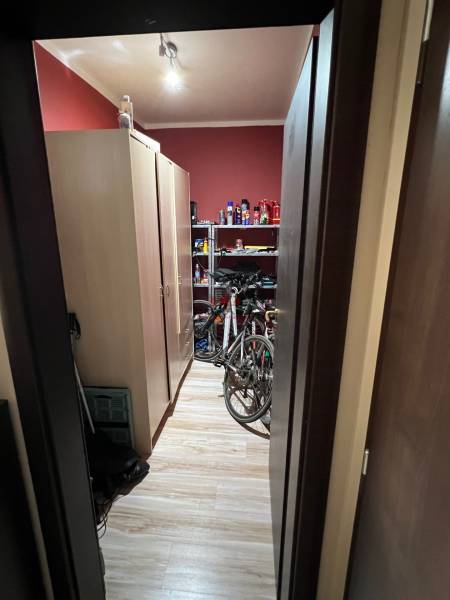 2iz byt v novostavbe Hlohovec Zľava!!! - Úložný priestor v 2-izbovom byte s policami, bicyklami a podlahou s dreveným dekorom.