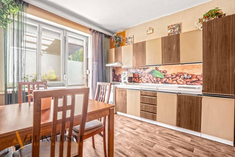 NA PREDAJ 6-IZBOVÝ RD S VEĽKÝM POZOMKOM, DOLNÝ ŠTÁL - Kuchyňa v rodinnom dome so svetlým nábytkom, dekorom kávy a podlahou s dreveným dekorom.