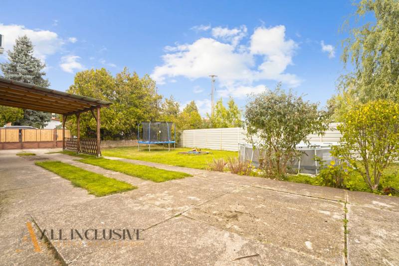 NA PREDAJ 6-IZBOVÝ RD S VEĽKÝM POZOMKOM, DOLNÝ ŠTÁL - Záhrada rodinného domu v Dolnom Štáli s trampolínou na tráve.