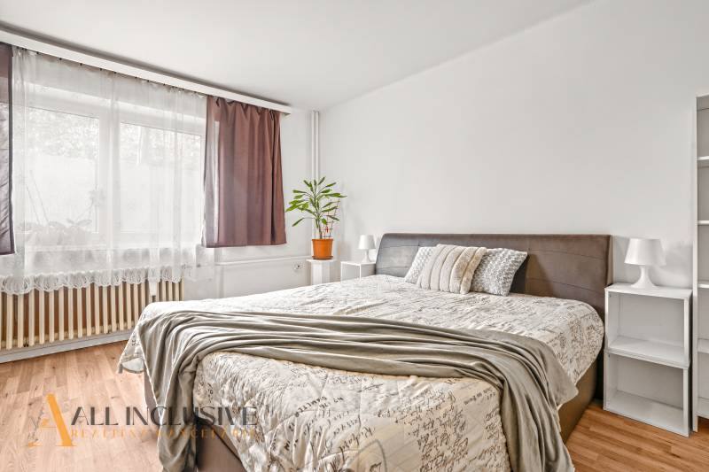 NA PREDAJ 6-IZBOVÝ RD S VEĽKÝM POZOMKOM, DOLNÝ ŠTÁL - Svetlá spálňa s pohodlnou posteľou, poličkou a podlahou s dreveným dekorom v rodinnom dome.