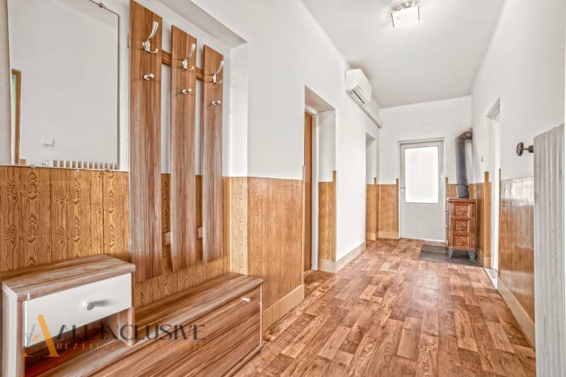 NA PREDAJ 6-IZBOVÝ RD S VEĽKÝM POZOMKOM, DOLNÝ ŠTÁL - Chodba s podlahou s dreveným dekorom, vešiakmi a dverami. Rodinný dom.