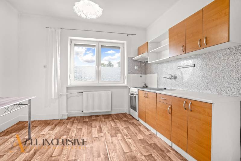 NA PREDAJ 6-IZBOVÝ RD S VEĽKÝM POZOMKOM, DOLNÝ ŠTÁL - Kuchyňa v rodinnom dome s podlahou s dreveným dekorom a bielymi stenami.