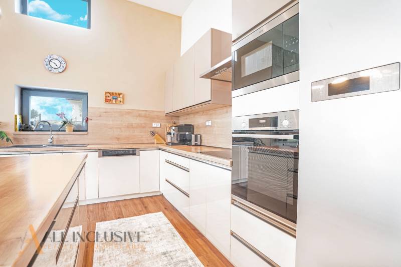 NA PREDAJ NADŠTANDARDNÁ 4-IZB. NOVOSTAVBA, DUN. KLÁTOV - Kuchyňa v rodinnom dome s modernými spotrebičmi a veľkým oknom.