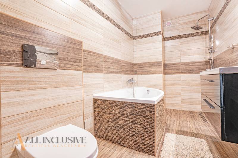 NA PREDAJ NADŠTANDARDNÁ 4-IZB. NOVOSTAVBA, DUN. KLÁTOV - Kúpeľňa v rodinnom dome s vaňou, sprchou a umývadlom, obklopená béžovými dlaždicami.