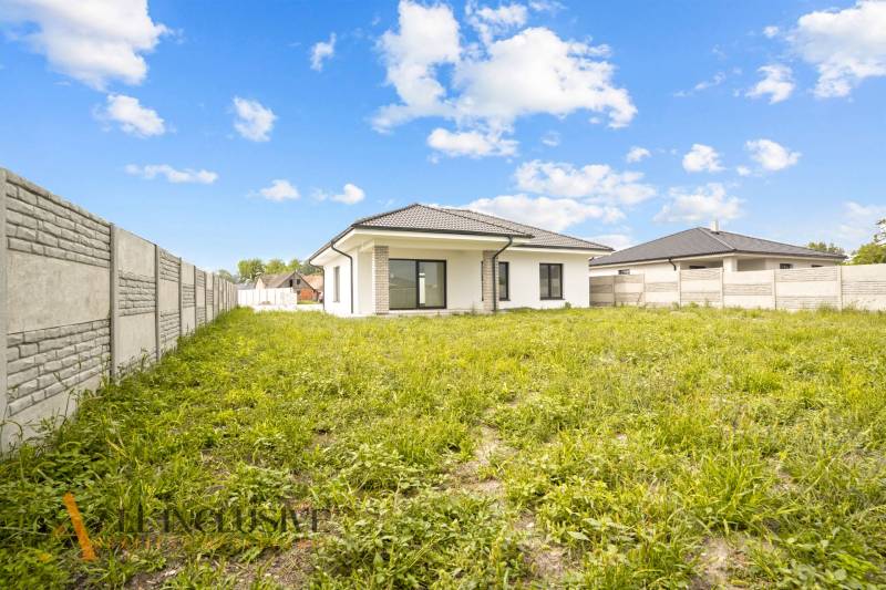 NA PREDAJ 4-IZBOVÁ NOVOSTAVBA, POVODA - Rodinný dom na Povode v Dunajskej Strede obklopený trávnatým pozemkom a plotom.