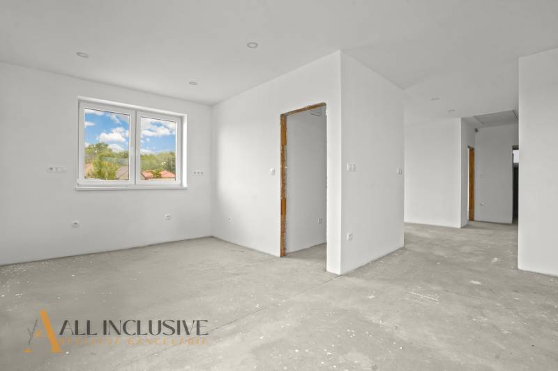 NA PREDAJ 4-IZBOVÁ NOVOSTAVBA, POVODA - Prázdny interiér rodinného domu s bielymi stenami a veľkým oknom.