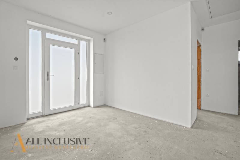 NA PREDAJ 4-IZBOVÁ NOVOSTAVBA, POVODA - Prázdna miestnosť s veľkými oknami a bielymi stenami v rodinnom dome.