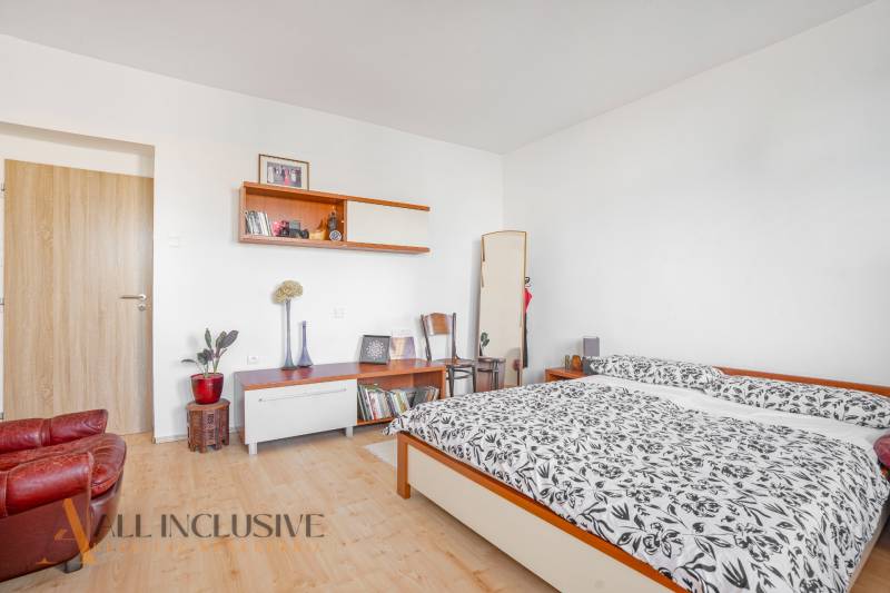 NA PREDAJ 5-IZBOVÝ POSCH. RODINNÝ DOM, DUNAJSKÁ STREDA - Spálňa v rodinnom dome s manželskou posteľou, policami a kreslom, svetlé steny.