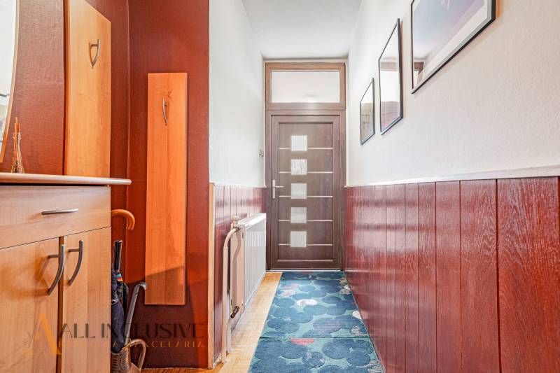 NA PREDAJ 5-IZBOVÝ POSCH. RODINNÝ DOM, DUNAJSKÁ STREDA - Chodba v rodinnom dome s dreveným obložením, vešiakom a dverami s matným sklom.