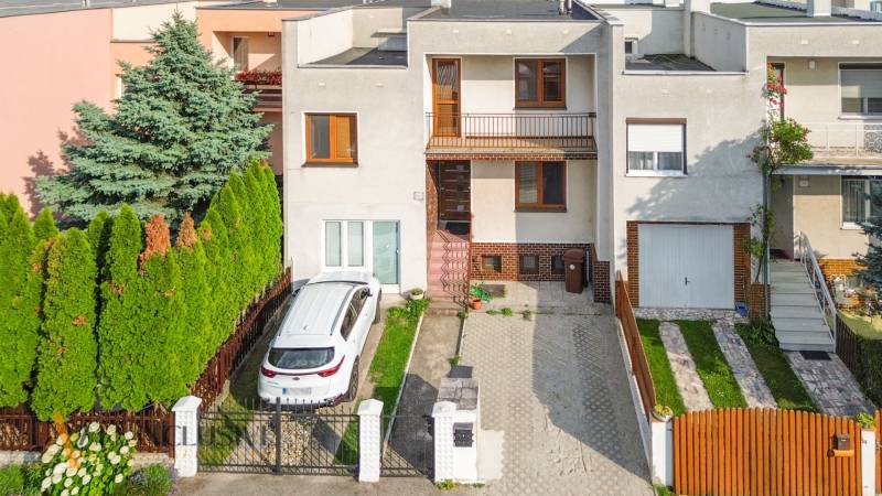 NA PREDAJ 5-IZBOVÝ POSCH. RODINNÝ DOM, DUNAJSKÁ STREDA - Rodinný dom v Dunajskej Strede s autom zaparkovaným na príjazdovej ceste pred záhradou.