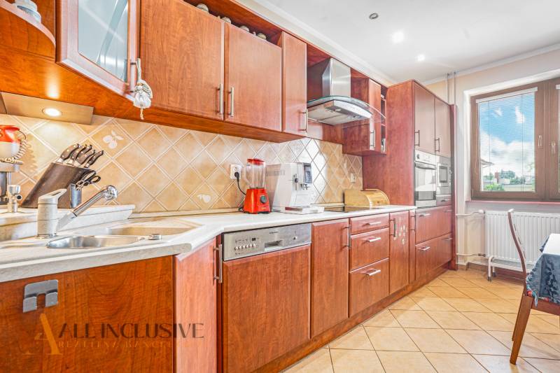 NA PREDAJ 5-IZBOVÝ POSCH. RODINNÝ DOM, DUNAJSKÁ STREDA - Kuchyňa s drevenými skrinkami, keramickým drezom a spotrebičmi v rodinnom dome.