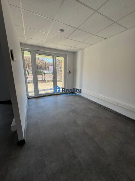 Prenájom obchod/kancelária NP nová kompletná rekonštrukcia, centrum PB - Priestranné obchodné priestory s veľkými oknami a výhľadom na vonkajšiu časť.