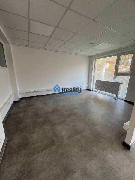 Prenájom obchod/kancelária NP nová kompletná rekonštrukcia, centrum PB - Svetlá izba v obchodných priestoroch s veľkým oknom a radiátorom.