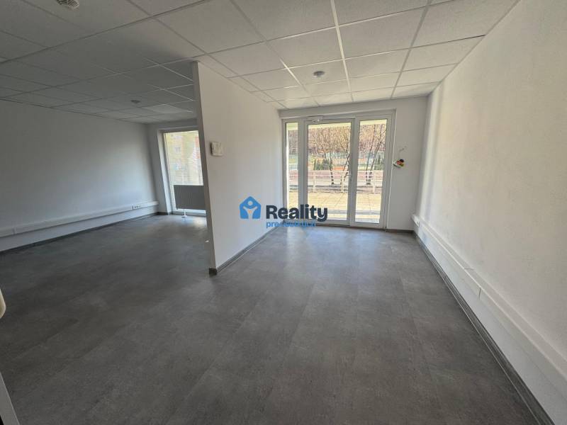 Prenájom obchod/kancelária NP nová kompletná rekonštrukcia, centrum PB - Priestranné obchodné priestory s veľkými oknami a bielymi stenami.