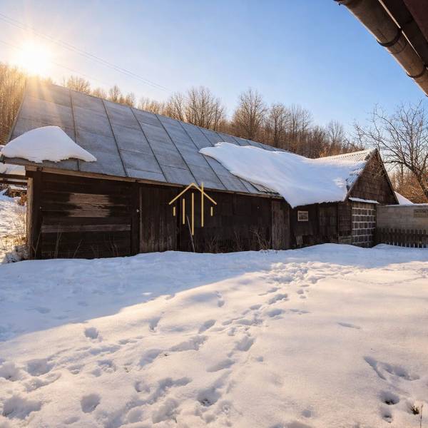 Predaj, rodinný dom Sliačany, Donovaly - Zasnežený rodinný dom v Donovaloch obklopený zimnou krajinou a stromami.