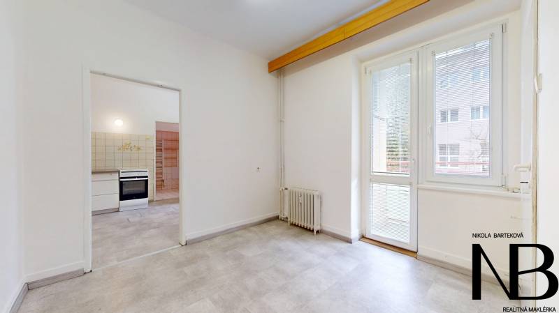 Na predaj 2,5 izbový byt v pôvodnom stave, 79 m2, Pod Sokolice, TN - Interiér 2-izbového bytu s podlahou s dreveným dekorom a prístupom na balkón.