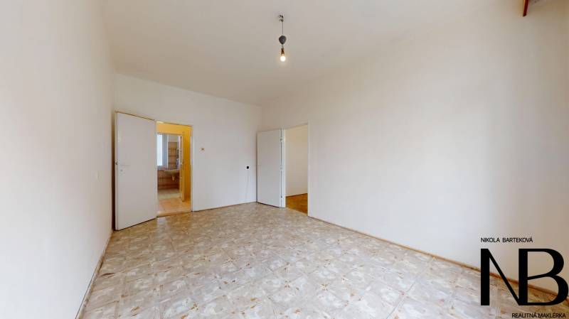 Na predaj 2,5 izbový byt v pôvodnom stave, 79 m2, Pod Sokolice, TN - Izba v 2-izbovom byte s keramickou podlahou a jednoduchým osvetlením bez zariadenia.