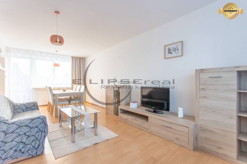 NA PREDAJ priestranný 4-izbový rodinný dom v Plaveckom Štvrtku - Obývacia izba s podlahou s dreveným dekorom, pohovkou a jedálenským stolom v rodinnom dome.