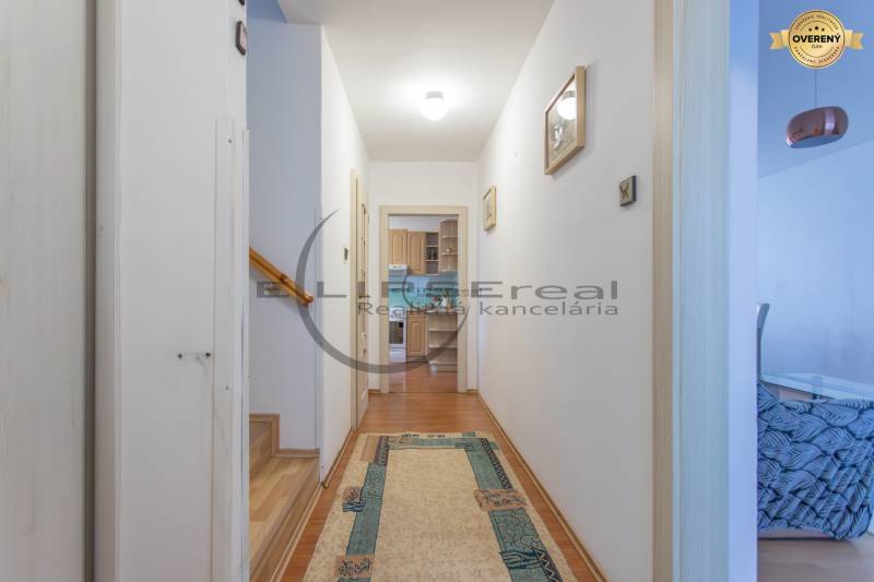 NA PREDAJ priestranný 4-izbový rodinný dom v Plaveckom Štvrtku - Chodba v rodinnom dome s podlahou s dreveným dekorom a schodiskom.