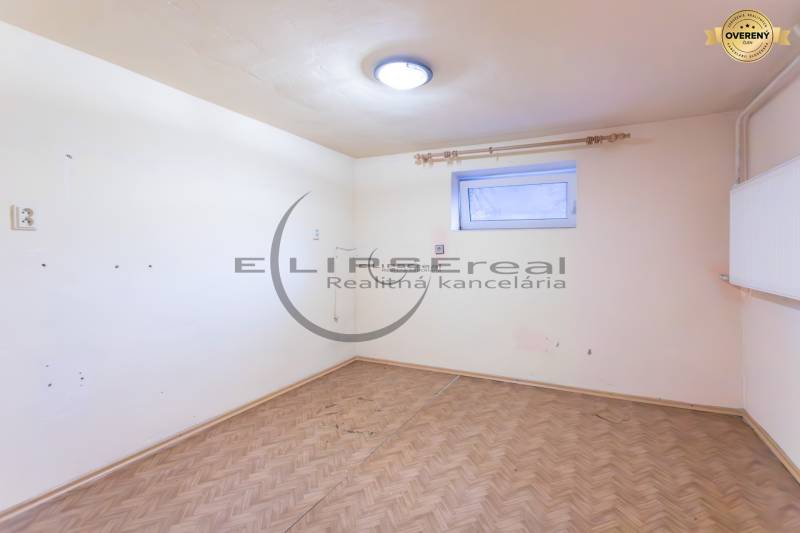 NA PREDAJ priestranný 4-izbový rodinný dom v Plaveckom Štvrtku - Prázdna izba v rodinnom dome s podlahou s dreveným dekorom a malým oknom.