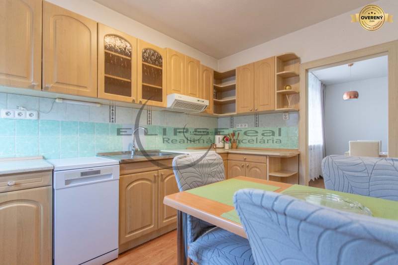 NA PREDAJ priestranný 4-izbový rodinný dom v Plaveckom Štvrtku - Kuchyňa v rodinnom dome má drevené skrinky, kachličkový obklad a jedálenský stôl.