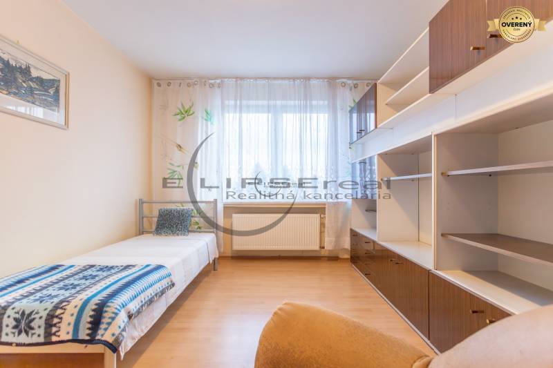 NA PREDAJ priestranný 4-izbový rodinný dom v Plaveckom Štvrtku - Izba v rodinnom dome s posteľou, skrinkami a podlahou s dreveným dekorom.