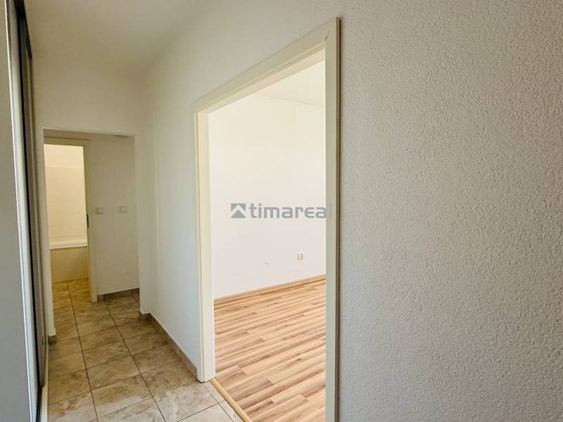 EXKLUZÍVNE - Pekný 1i byt po rekonštrukcii 38m2, loggia, Na hlinách - Chodba vedie do izby v 1-izbovom byte s podlahou s dreveným dekorom.