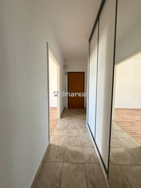 EXKLUZÍVNE - Pekný 1i byt po rekonštrukcii 38m2, loggia, Na hlinách - Chodba 1-izbového bytu s dlažbou, vstavanou skriňou a zrkadlom, podlaha s dreveným dekorom.