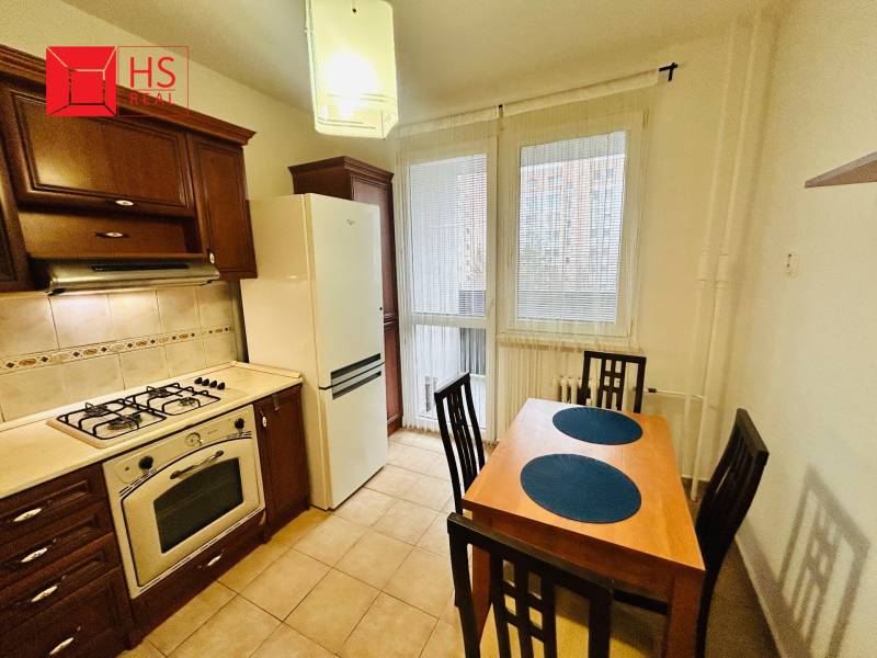 Prenajom 3 izb. bytu na Vajanskeho v NZ - Kuchyňa v 3-izbovom byte s plynovým sporákom, jedálenským stolom a dlažbou.