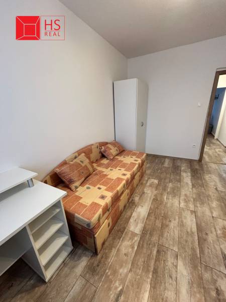 Prenajom 3 izb. bytu na Vajanskeho v NZ - Izbový nábytok so sedačkou a podlahou s dreveným dekorom v 3-izbovom byte.