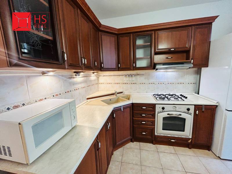 Prenajom 3 izb. bytu na Vajanskeho v NZ - Kuchyňa v 3-izbovom byte s tmavým dreveným dekorom a kachličkami.